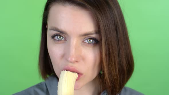 Face of Young Woman Eating Banana