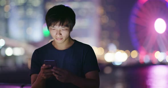 Man use of cellphone in city at night