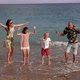 A Family with Children is Relaxing and Having Fun on the Beach They Jump - VideoHive Item for Sale
