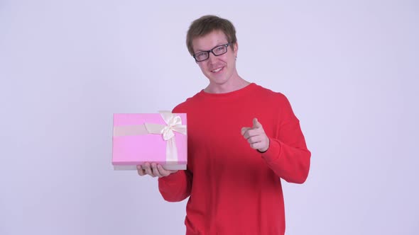 Happy Young Handsome Man Holding Gift Box