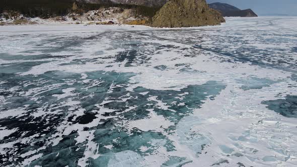 Lake scenery with coastal rocks on frosty winter day. Amphibious craft in motion