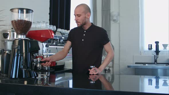 Male Barista Using the Coffee Machine Preparing Coffee for a Client