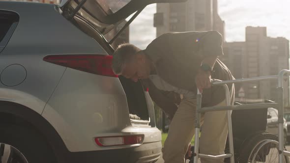 Man with Disability Putting Walkers in Car Trunk