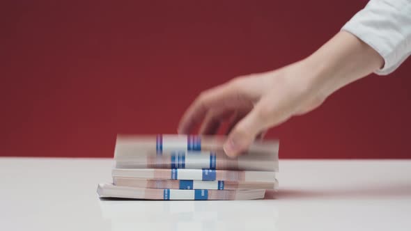 A Woman's Hand Puts the Euro on the Table