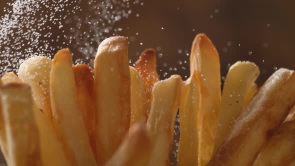 Adding salt on french fries. Slow Motion.