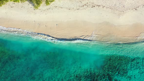 Wide Angle Aerial Clean View of A Sunshine White Sandy Paradise Beach and Aqua Turquoise Water