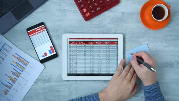 Businessman Writes Stock Data From Tablet Screen.