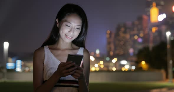 Woman working on cellphone at night 