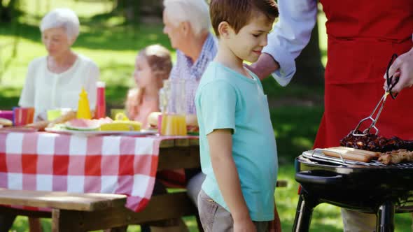 Father and son preparing food on barbecue