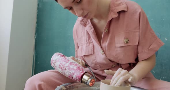 Female Potter Sitting and Firing a Shape Cup Clay on the Pottery Wheel. Woman Making Ceramic Item