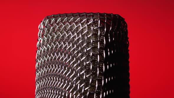 Studio Condenser Microphone Rotates on Red Background.