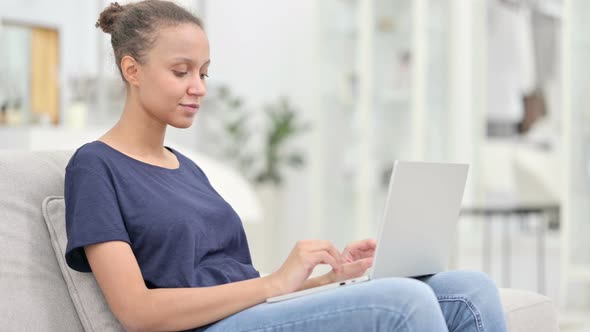 Focused African Woman Working on Laptop at Home 