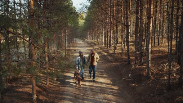 Couple and Dog Walking in Forest on Spring Day