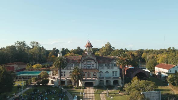 Aerial dolly out of Tigre private rowing club building near de la Plata river surrounded by trees at