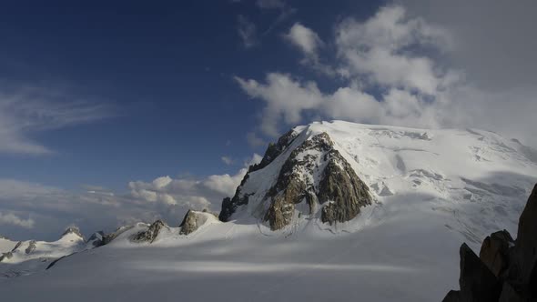 Time lapse view of clouds moving over majestic, snow-covered mountains