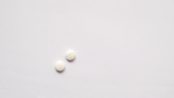 Slow Motion of White Color Medical Pills Drop on Table