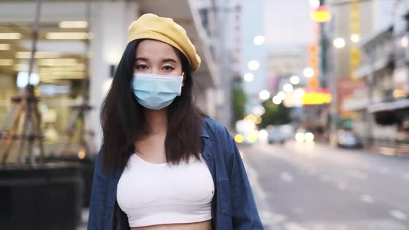 Asian woman standing outdoor wearing protective mask, covid-19 world pandemic,