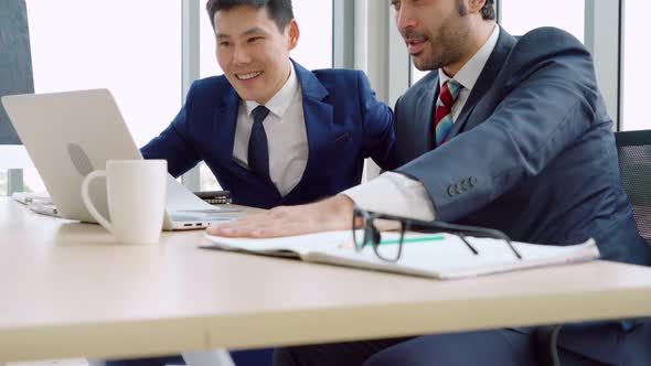 Two Business People Talk Project Strategy at Office