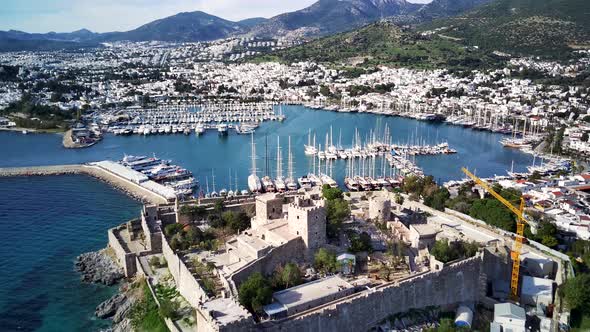 Amazing panoramic view from drone of full of yachts Bodrum harbour and ancient Kalesi castle.