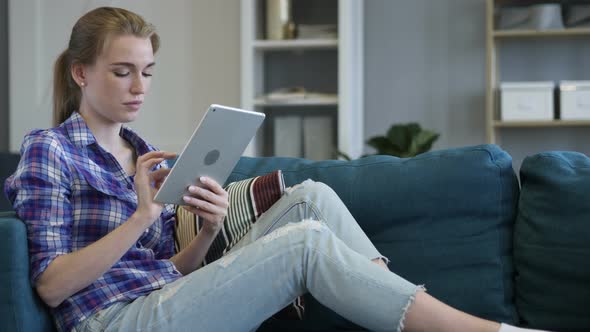 Relaxing Woman Sitting and Browsing Internet on Tablet