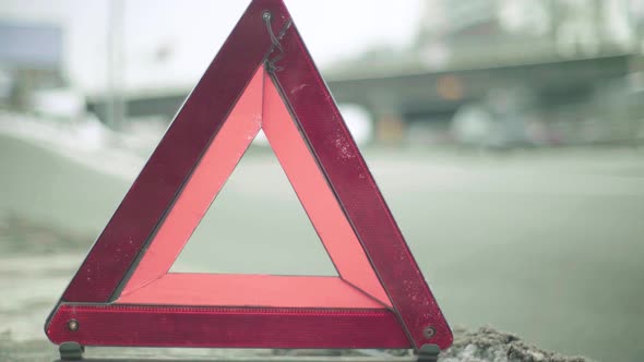 Warning Sign "Red Triangle" on the Road. Close-up. Crash. Car Breakdown