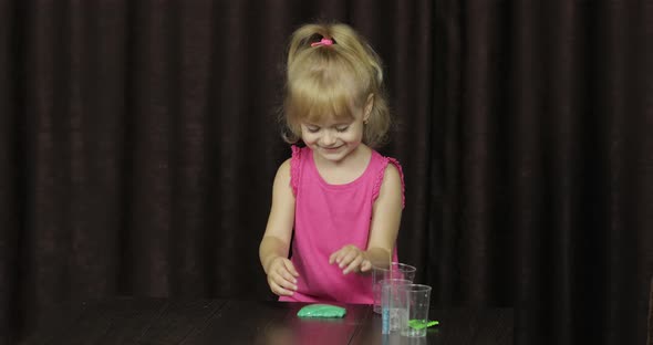 Child Having Fun Making Green Slime. Kid Playing with Hand Made Toy Slime