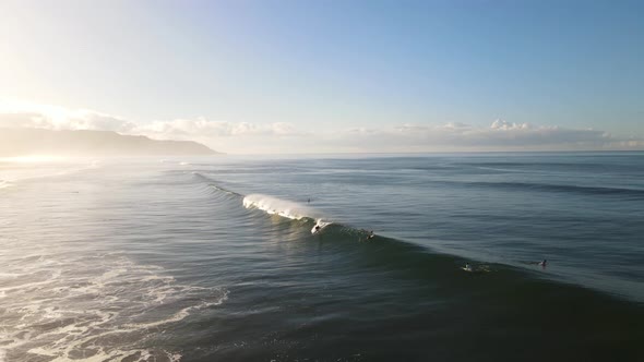 drone shot of surfer riding a large wave during sunrise in Costa Rica