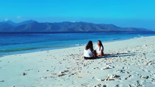 Girls best friends on beautiful sea view beach trip by blue water and white sand background of Bali 