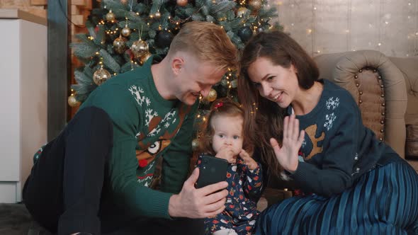 Lovely Family Talking Online While Having Fun Next To the Christmas Tree.