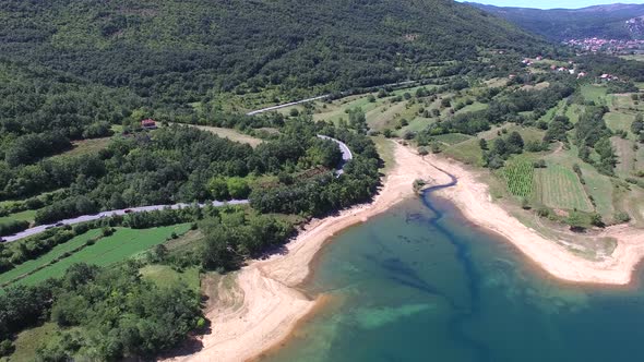 Flying above forested shore of artificial lake Peruca, Croatia