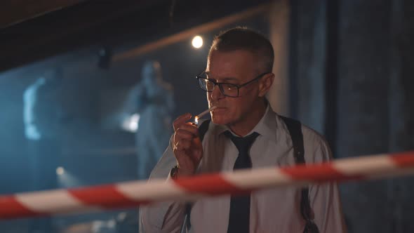 Aged Police Officer Smoking Cigarette at Crime Scene