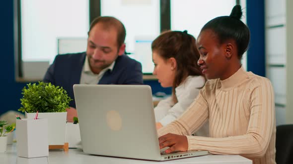 Cheerful African Business Lady Typing on Laptop and Smiling Sitting at Desk