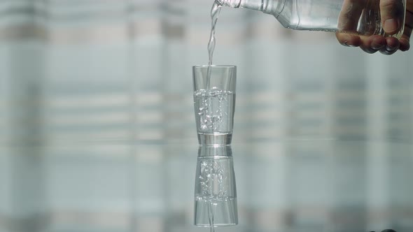 Hand of a man who pours vodka into a glass