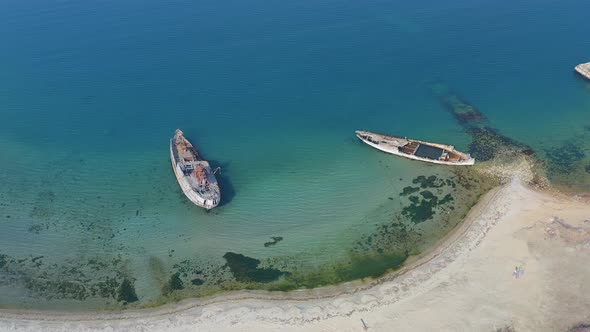 A Wrecked Wooden Ship Lies on the Seashore Covered with Rust