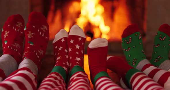 Family in Christmas socks near fireplace