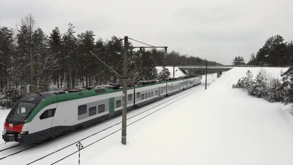 Intercity Modern Electric Train Rides on Snowcovered Rails