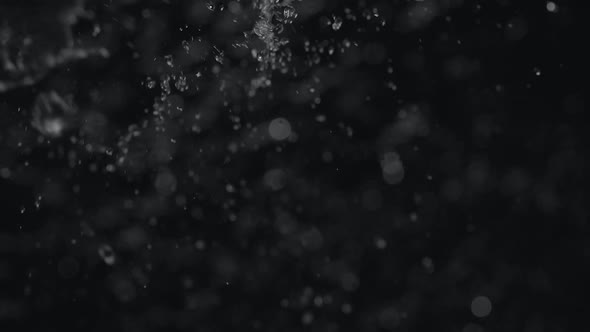 Camera follows raining on water. Slow Motion.