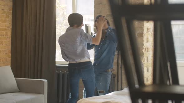 Cheerful Young Interracial Couple Dancing in Bedroom and Smiling. Positive African American Man and