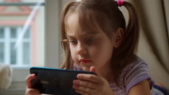 Cute Preschool Girl Using Smartphone at Home