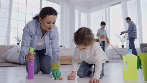 Mother with Little Daughter Wiping Floor at Home