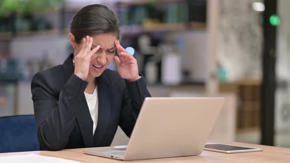 Stressed Young Indian Businesswoman with Laptop Having Headache in Cafe