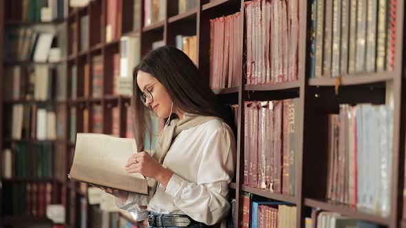 Girl Reading Book Near Bookshelf