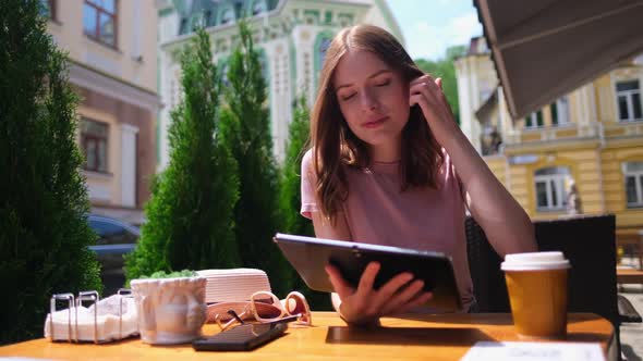 Young Woman Using Tablet Pc in a Cafe on a Summer Terrace