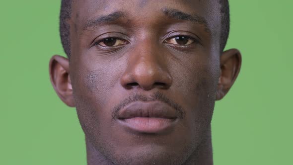 Head Shot of Young African Man Against Green Background