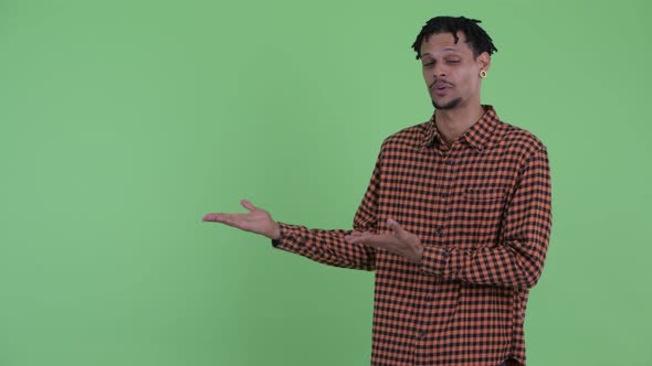 Happy Young Handsome African Man Talking While Showing Something