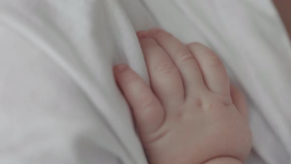 Close Up of Little Child Hand Touching Mother's Shoulder
