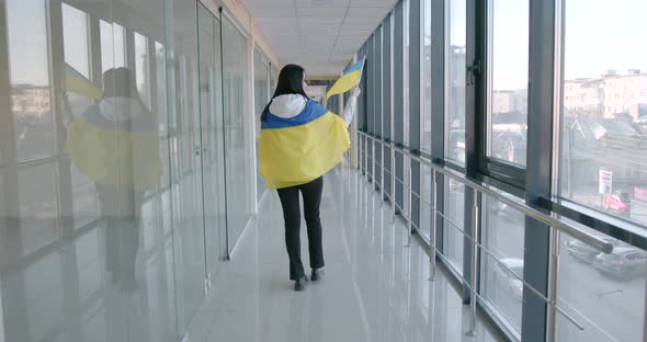 Young Woman Holding Ukrainian Flag in the Modern Building