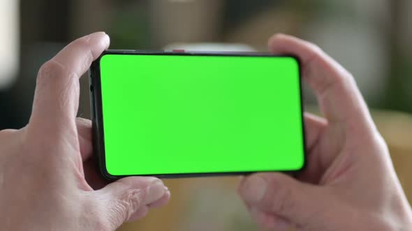 Holding Horizontal Smartphone with Green Chroma Screen