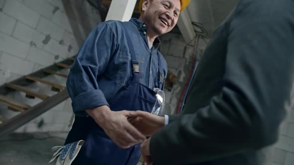 Builder Shaking Hands with Businessman