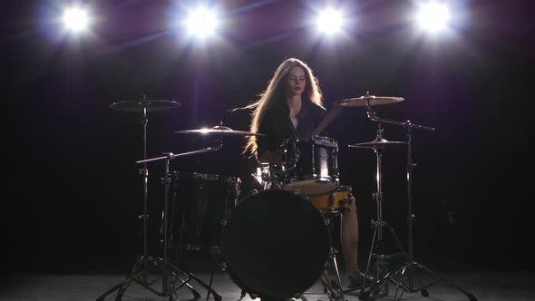 Drummer Girl Starts Playing Energetic Music, She Smiles. Black Background